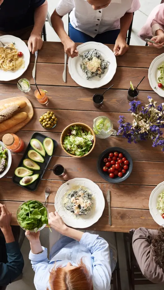 Photo : une table de repas entre amis vue du dessus.